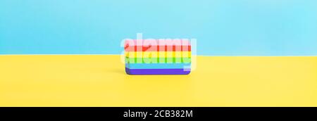 A multi colored eraser on a yellow and blue background. Colors of rainbow. Long banner Stock Photo