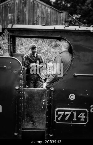 Mono steam train crew fireman filling vintage steam locomotive with ...