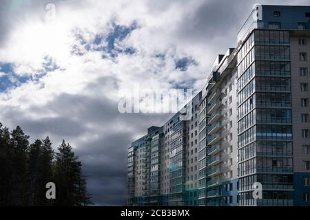Krasnoyarsk, Russia, August 10, 2020: residential building with balconies against the dark sky, on the edge of the forest. Modern eco-friendly area fo Stock Photo