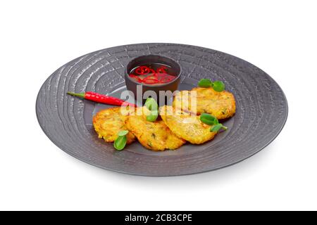 Zucchini pancakes served with chili sauce isolated on white Stock Photo