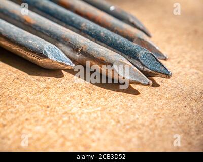 Iron nails on a wooden table macro photo. Stock Photo