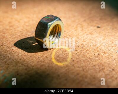 Iron nut on a wooden table macro photo. Stock Photo