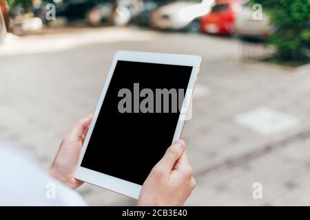 Woman holding digital tablet in her hands outdoors Stock Photo