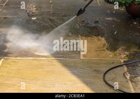 Patio Cleaning. Pressure washing an Indian slate patio. Stock Photo