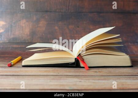 open book and a pencil on wooden table  Stock Photo