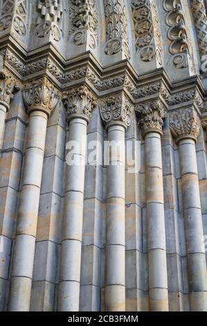 Detail of old ancient historic building made in neo-romanesque architectural style - decorated portal with columns. Vertical lines