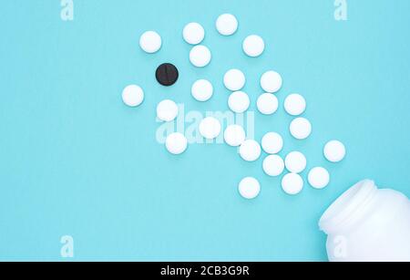 Scattered pills white and black on blue background. Out of the box thinking, Be different concept. 