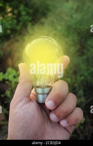 Person holding a glowing light bulb Stock Photo