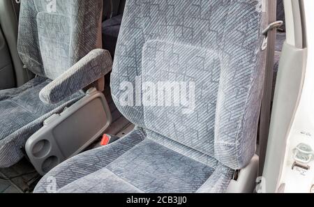 Comfortable front seats inside the car: the driver and passenger, tied with textile velour, modern interior design in workshop. Auto service industry. Stock Photo