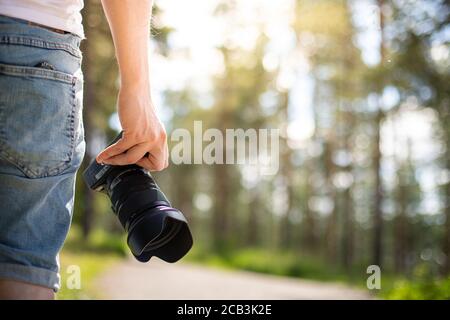 Photographer holding a camera in a park getting ready to take photos Stock Photo