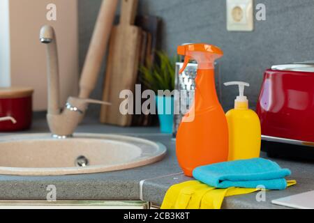 Household chemicals product bottles standing near the kitchen sink Stock Photo