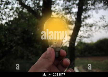Person holding a glowing light bulb Stock Photo