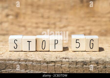 Wooden cubes with the word STOP 5G on wooden background, technolegy mobile concept Stock Photo