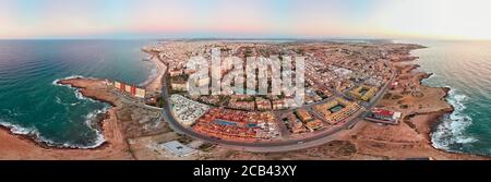 Aerial panoramic wide angle photo of Torrevieja cityscape, rocky coastline Mediterranean Sea during sunrise, Salt lake or Las Salinas, image view from