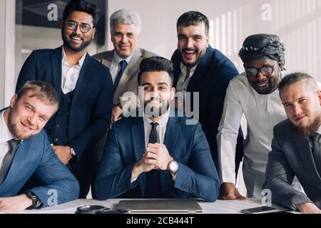 Formal meeting of several multi-ethnic male colleagues gathered in executive s office to discuss new ideas Stock Photo