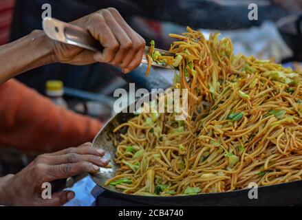 Stiring the Chow Mein at a street food stall in Assam, India Stock Photo