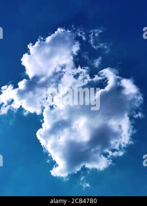 Single fluffy cloud in the blue sky Stock Photo