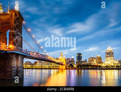 Nighttime view of John A. Roebling Suspension Bridge over the Ohio River and downtown Cincinnati skyline Stock Photo