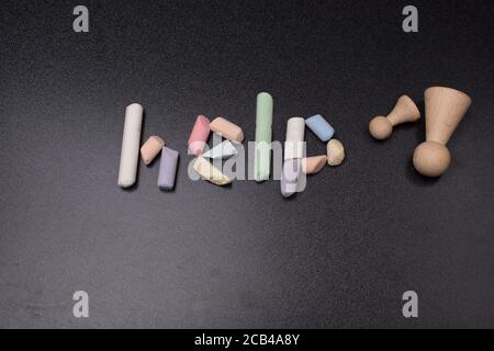Help word written incoloured chalk on a black chalkboard. Stock Photo
