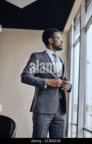 awesome employee in fashion grey suit standing near thw window. low angle view .job, profession Stock Photo
