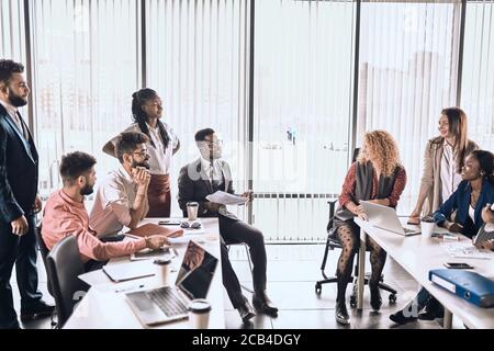 a group of young people divided into two parts as they have different opnions on business plan . people are sharing with experience Stock Photo