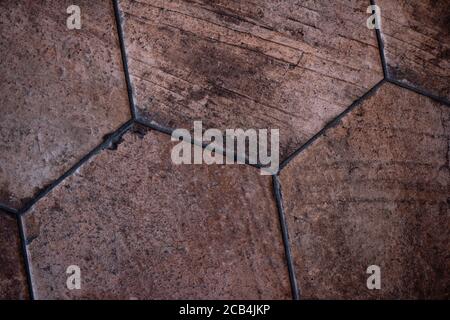 Vintage brown ceramic tile in the form of honeycombs. Hexagonal floor tiles. Stock Photo