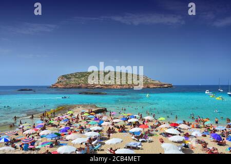 IBIZA, SPAIN - JULY 13, 2017: Tourists relax on Cala Comte, famous beach of Ibiza island. Stock Photo