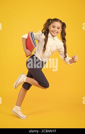 Back to school. Kid cheerful schoolgirl running. Pupil want study. Active child in motion. Beginning school lesson. Keep going. Active kid. Hurry up. Girl with books on way to school. Knowledge day. Stock Photo