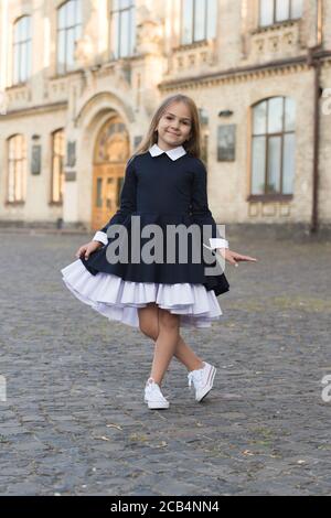 Its pleasure of elegance. Happy kid make curtsy in uniform outdoors. Uniform dress code. Clothing standards. Fashion school uniform. Formal style. Elementary education. September 1. Stock Photo