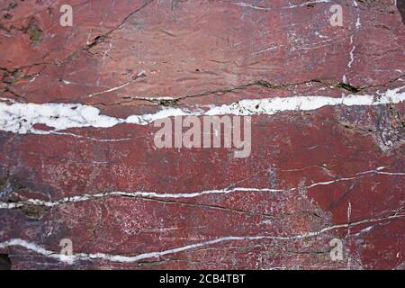 Texture of natural red granite with veins of white. The mineral cut. Can be used as a background. Stock Photo