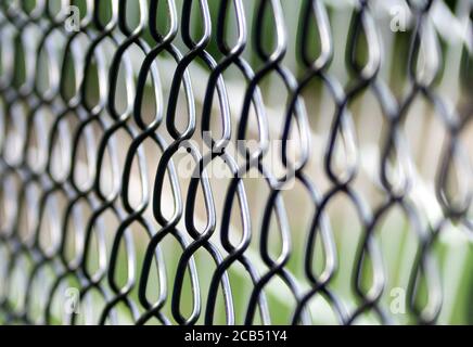 A wire mesh fence in front of a soccer goal net. Stock Photo