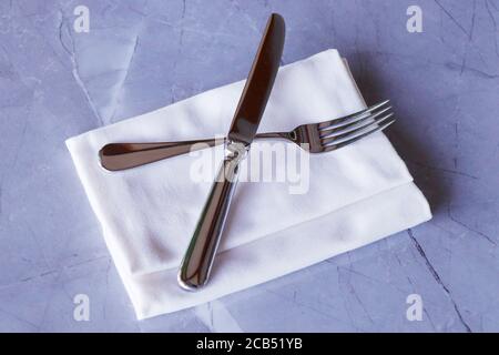 restaurant cutlery, knife and fork on a table with napkin Stock Photo