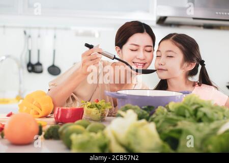 happy mother and child Smelling Aroma from Saucepan