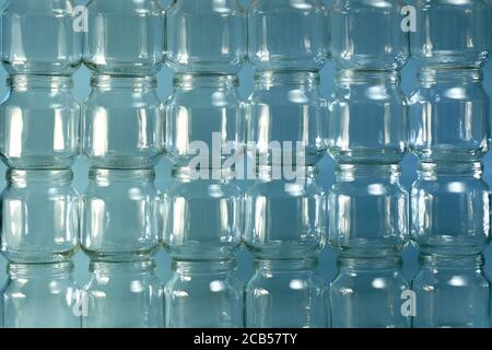 The background is from of transparent small cans, large fragment of a lined wall of cans placed on top of each other. Stock Photo