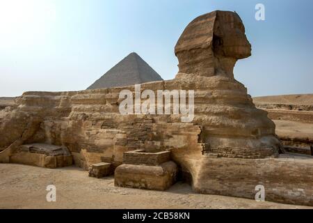 The Great Sphinx of Giza and the Pyramid of Khufu located on the Giza Plateau at Cairo, Egypt. The Sphinx was carved from bedrock. Stock Photo