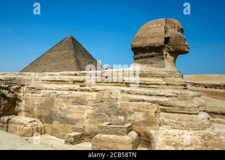 The Great Sphinx of Giza and the Pyramid of Khufu located on the Giza Plateau in Cairo, Egypt. The Sphinx was carved from bedrock. Stock Photo