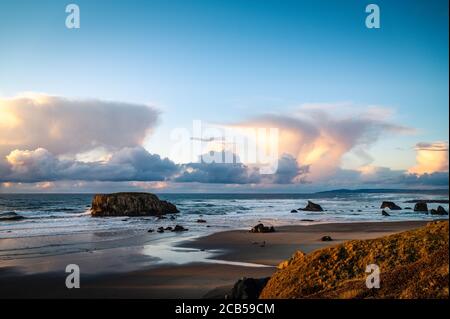 Storm clouds at sunset over rocky beach at Oregon Coast.  Stock Photo