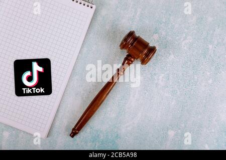 WASHINGTON D.C., USA - AUGUST 05, 2020: Conflict between the President of the United States and the Chinese company tik tok Overhead of notepad with wooden judges gavel on a desk Stock Photo