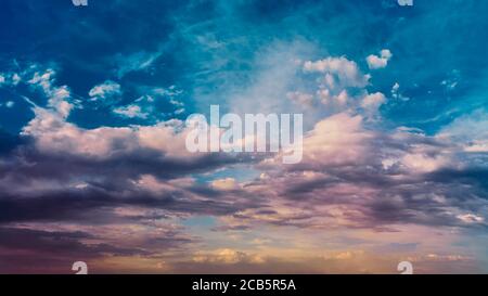 Bright sunlight shining through the clouds against the backdrop of a breathtaking evening sky at sunset. panorama, natural composition Stock Photo