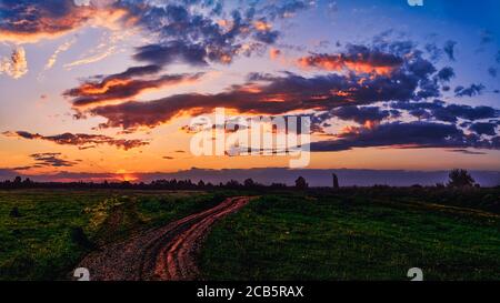 Bright sunlight shining through the clouds against the backdrop of a breathtaking evening sky at sunset. panorama, natural composition Stock Photo