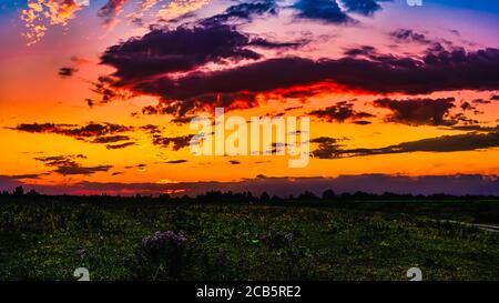Bright sunlight shining through the clouds against the backdrop of a breathtaking evening sky at sunset. panorama, natural composition Stock Photo