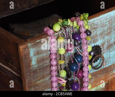close up colorful jewellery in old painted wooden drawer Stock Photo