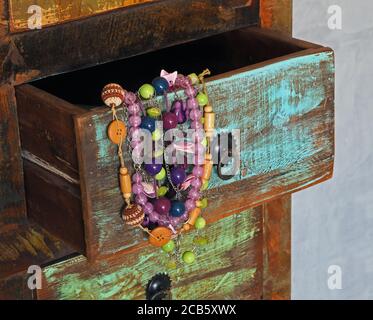 close up colorful jewellery in old painted wooden drawer Stock Photo