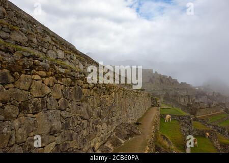 Landscape of Machu Picchu covered in the fog at daytime in Peru Stock Photo