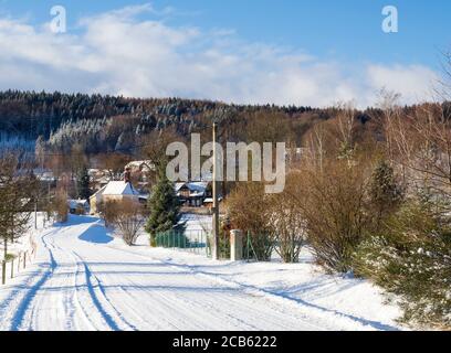 winter view on village travnik with chapel, timbered cottage and trees, snow covered rural landscape with in luzicke hory mountain Stock Photo