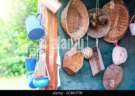Second-hand blue saucepans, small bucket , jug and old straw baskets turn into garden flower pots. Recycled garden design and low-waste lifestyle. Reduce, reuse, recycle planter craft ideas. Stock Photo