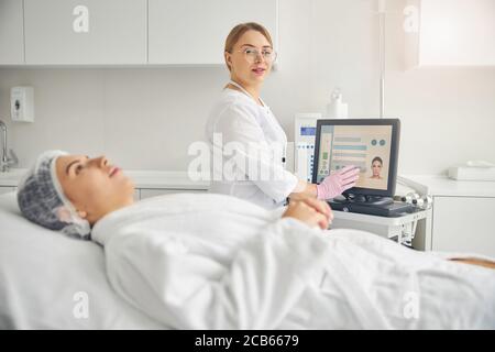 Pleased cosmetologist in eyeglasses posing for the camera Stock Photo