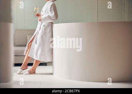 Woman with a drink standing in the foyer Stock Photo