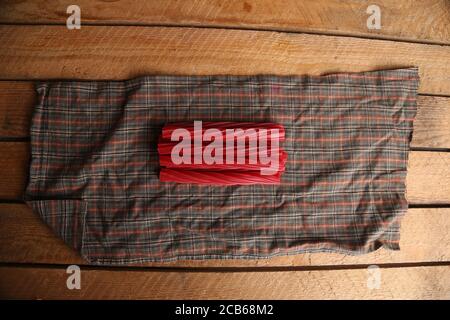 High angle shot of a bunch of stick candies on a cloth on a wooden surface Stock Photo