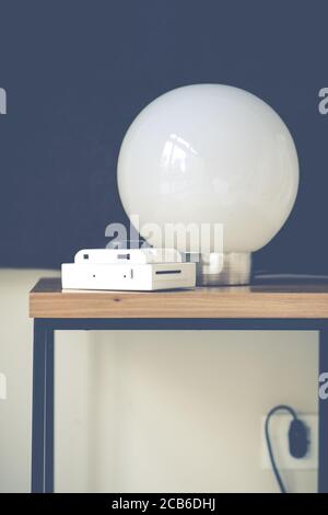 Vertical shot of a round lamp and a camera on the table Stock Photo